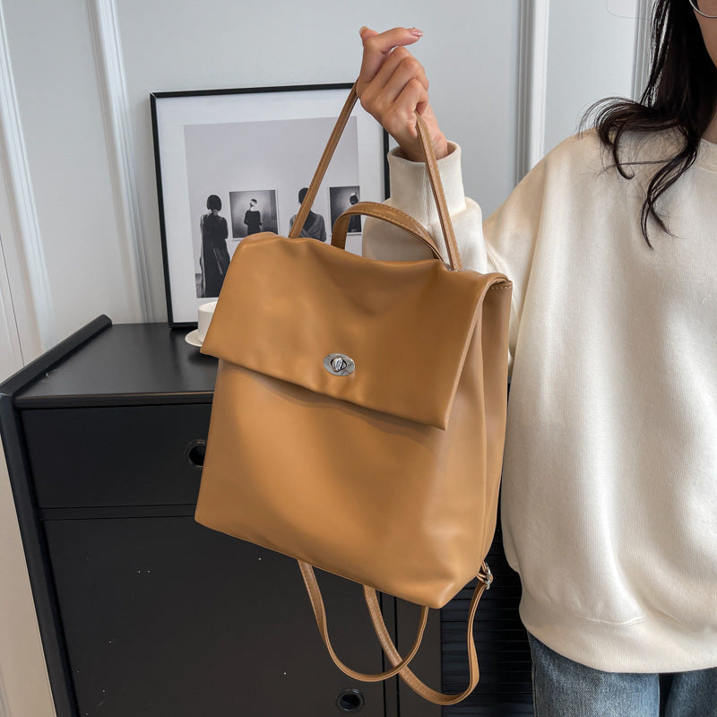 Feldacks black vintage style backpack purse held by woman in cream sweater with tan leather design
