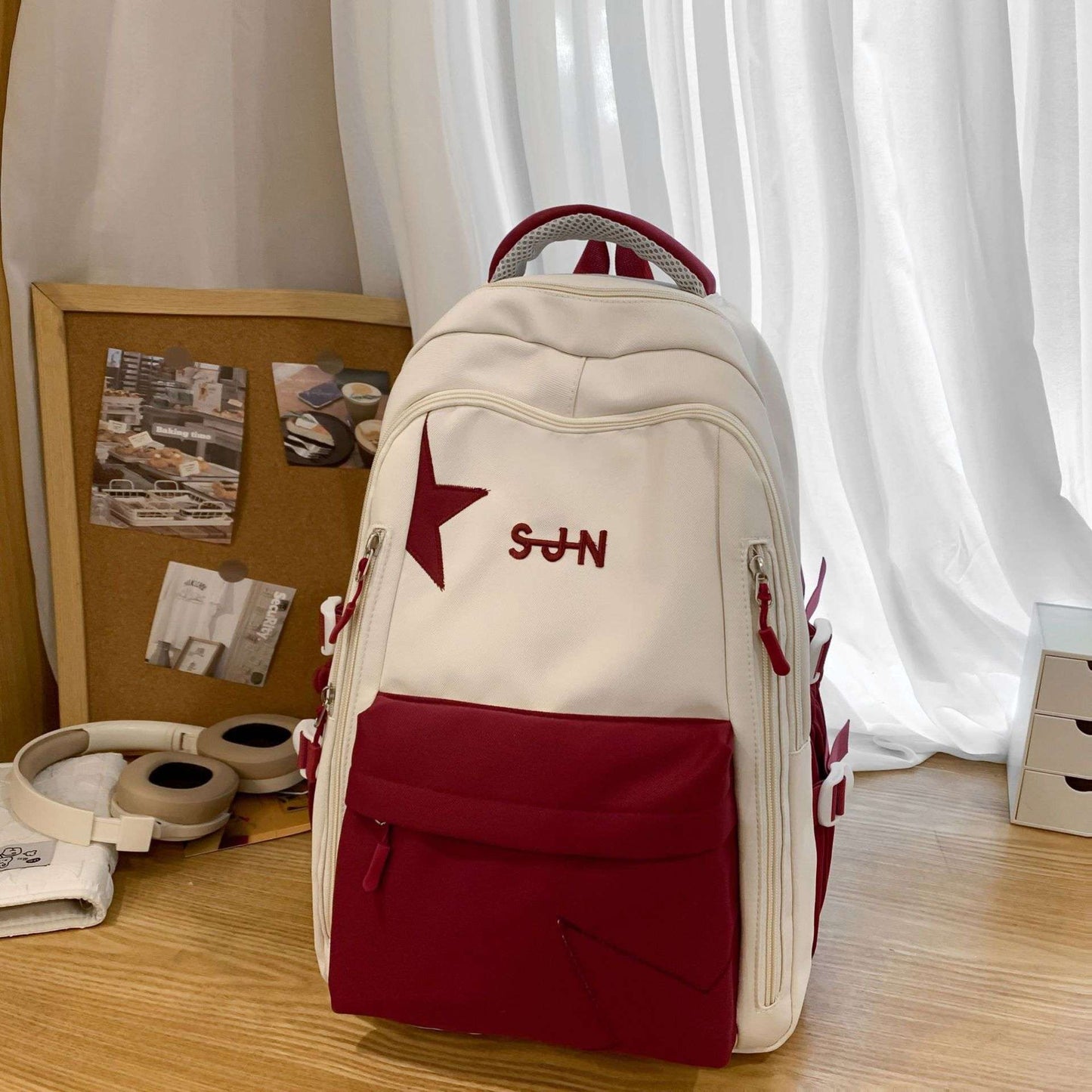 Feldacks pastel aesthetic school backpack in cream and burgundy with star design on wooden desk