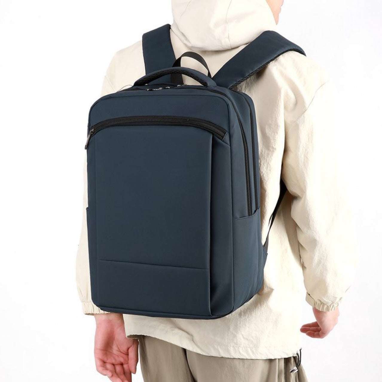 Feldacks professional commuter backpack for work in navy blue worn by person with beige jacket