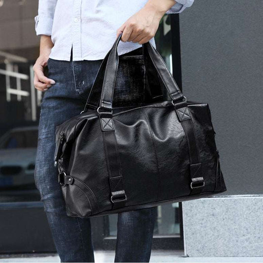 Feldacks VoyagerX waterproof duffel bag in black carried by person wearing jeans and white shirt